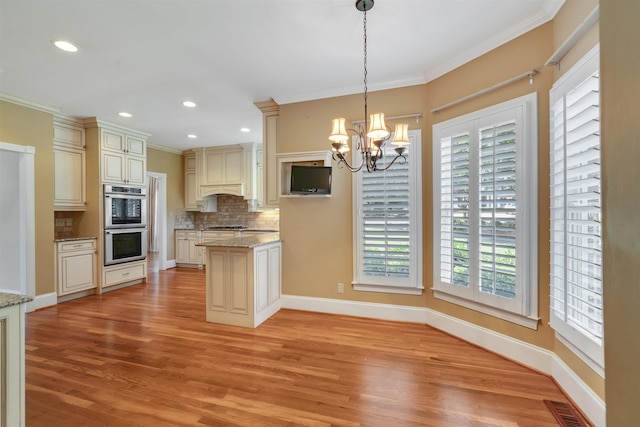 121 Commons, Spartanburg, SC 29302 - kitchen featuring double oven, cream cabinetry, light wood finished floors, ornamental molding, and a chandelier
