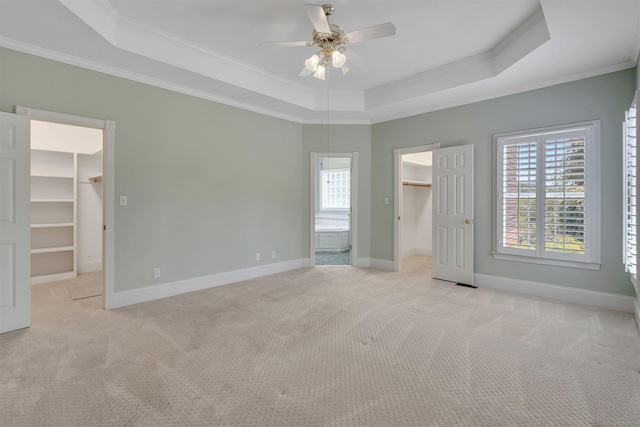 121 Commons, Spartanburg, SC 29302 - unfurnished bedroom featuring a spacious closet, a closet, a tray ceiling, ornamental molding, and light colored carpet