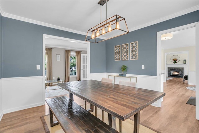 16 Chariot, Simpsonville, SC 29681 - dining area featuring light wood-style flooring, ornamental molding, a high end fireplace, a chandelier, and wainscoting