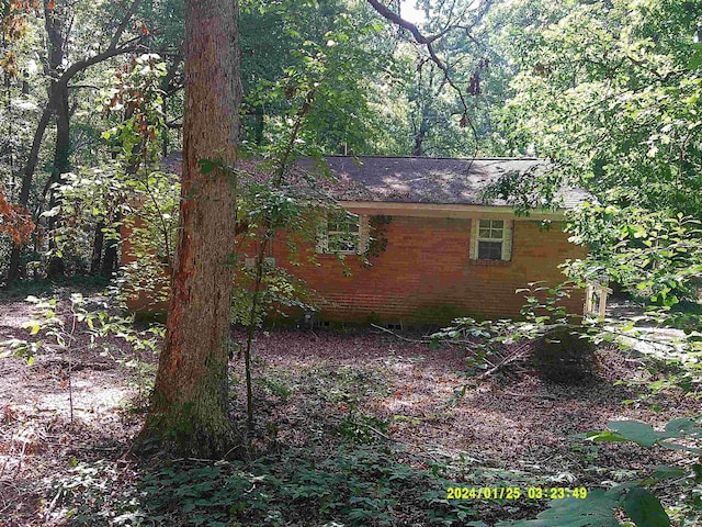796 Neal, Woodruff, SC 29388 - view of side of home with brick siding, a wooded view, and roof with shingles