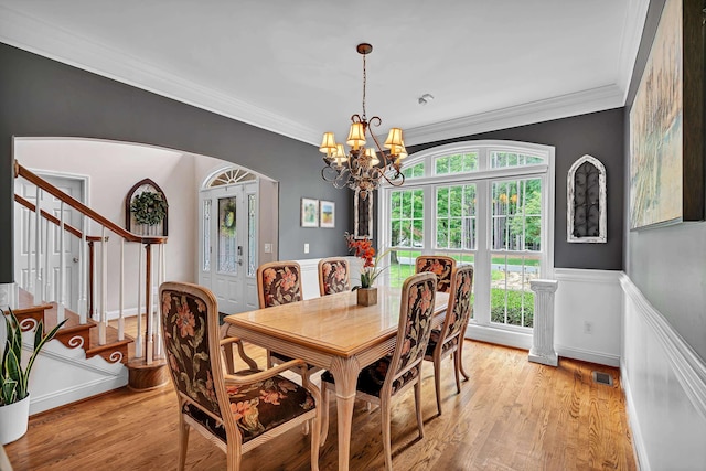 2030 Fasana, York, SC 29745 - dining room featuring arched walkways, ornamental molding, stairway, a chandelier, and a wainscoted wall