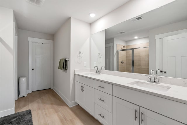 609 Cartmel, Greer, SC 29651 - bathroom featuring double vanity, a shower stall, baseboards, wood finished floors, and recessed lighting