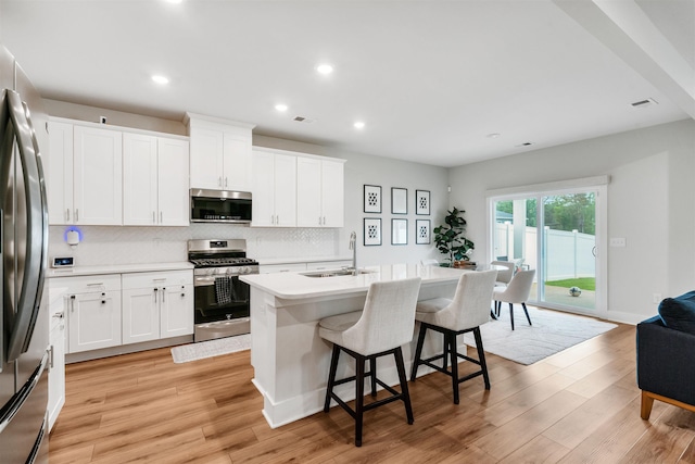 609 Cartmel, Greer, SC 29651 - kitchen featuring appliances with stainless steel finishes, a sink, decorative backsplash, a breakfast bar, and light countertops