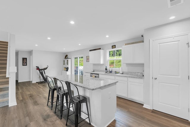 2097 Evanston, Wellford, SC 29385 - kitchen with a kitchen bar, a kitchen island, white cabinetry, light stone counters, and dark wood-style flooring