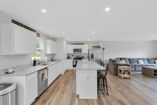 2097 Evanston, Wellford, SC 29385 - kitchen with stainless steel appliances, a sink, a kitchen bar, light wood-style floors, and a kitchen island