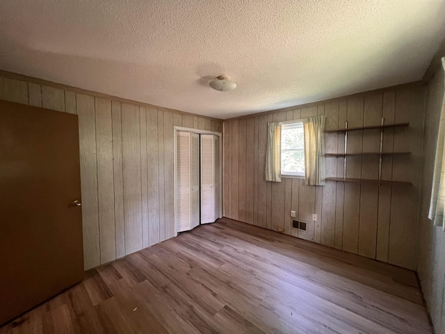 109 Berry, Boiling Springs, SC 29316 - unfurnished bedroom with wood finished floors, a closet, wood walls, and a textured ceiling