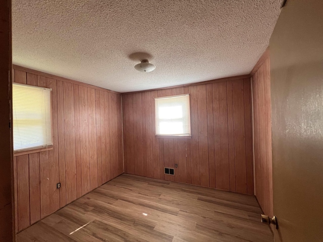 109 Berry, Boiling Springs, SC 29316 - unfurnished room with light wood-style flooring, wood walls, and a textured ceiling