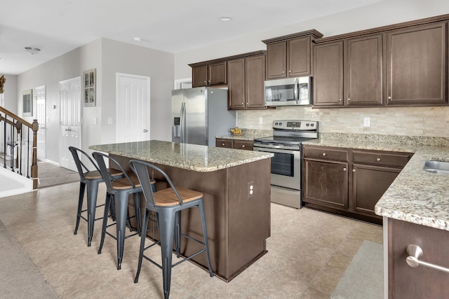 241 Hartleigh, Lyman, SC 29365 - kitchen featuring stainless steel appliances, backsplash, a kitchen island, a kitchen breakfast bar, and dark brown cabinets