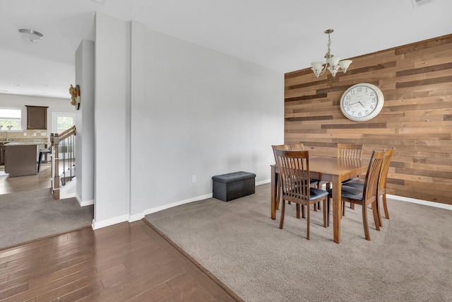 241 Hartleigh, Lyman, SC 29365 - dining room featuring wooden walls, a chandelier, wood finished floors, baseboards, and carpet floors