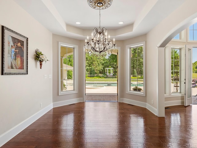 220 Fincher, Pauline, SC 29374 - unfurnished dining area featuring wood-type flooring, arched walkways, baseboards, a chandelier, and a raised ceiling