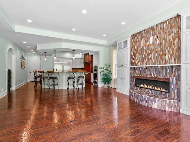 220 Fincher, Pauline, SC 29374 - kitchen with a glass covered fireplace, a kitchen bar, stainless steel appliances, dark wood-type flooring, and baseboards