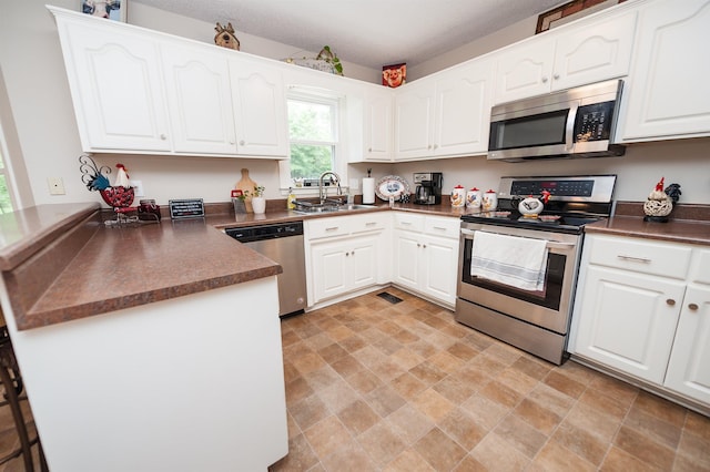 477 Cresthaven, Boiling Springs, SC 29316 - kitchen with stainless steel appliances, a sink, a peninsula, dark countertops, and white cabinets
