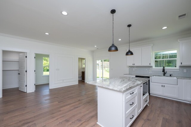 103 Cedar Fls, Fountain Inn, SC 29644 - kitchen with crown molding, plenty of natural light, decorative backsplash, white cabinets, and a center island