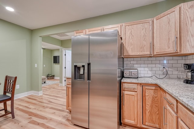 627 Branch, Woodruff, SC 29388 - kitchen featuring stainless steel fridge with ice dispenser, light wood-type flooring, backsplash, light stone counters, and light brown cabinetry