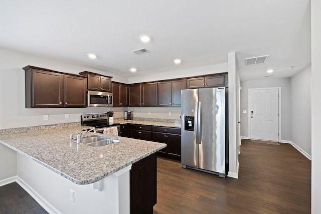 259 Millen, Woodruff, SC 29388 - kitchen with stainless steel appliances, dark brown cabinetry, a peninsula, dark wood-type flooring, and light stone countertops