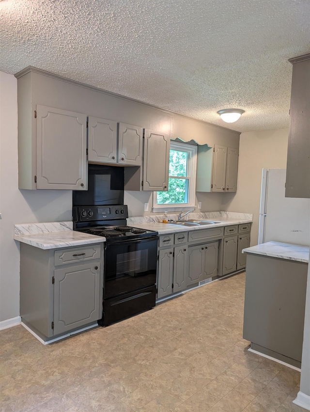 126 Loblolly, Wellford, SC 29385 - kitchen featuring black range with electric cooktop, gray cabinetry, a textured ceiling, light countertops, and freestanding refrigerator
