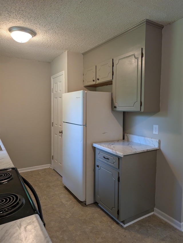 126 Loblolly, Wellford, SC 29385 - kitchen with black range with electric cooktop, freestanding refrigerator, a textured ceiling, light countertops, and gray cabinetry