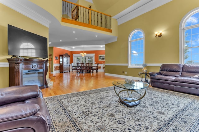 410 Anchorage, Inman, SC 29349 - living room with ornamental molding, wood finished floors, healthy amount of natural light, a glass covered fireplace, and a towering ceiling