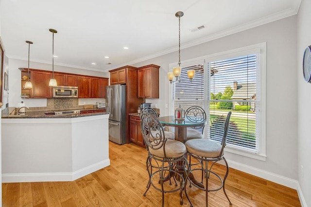 325 Reflection, Lyman, SC 29365 - kitchen with stainless steel appliances, healthy amount of natural light, tasteful backsplash, light wood-type flooring, and crown molding