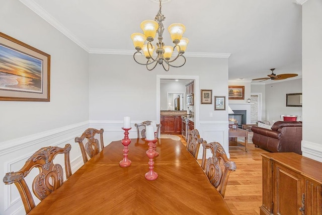 325 Reflection, Lyman, SC 29365 - dining area with a chandelier, ceiling fan, crown molding, a lit fireplace, and a wainscoted wall