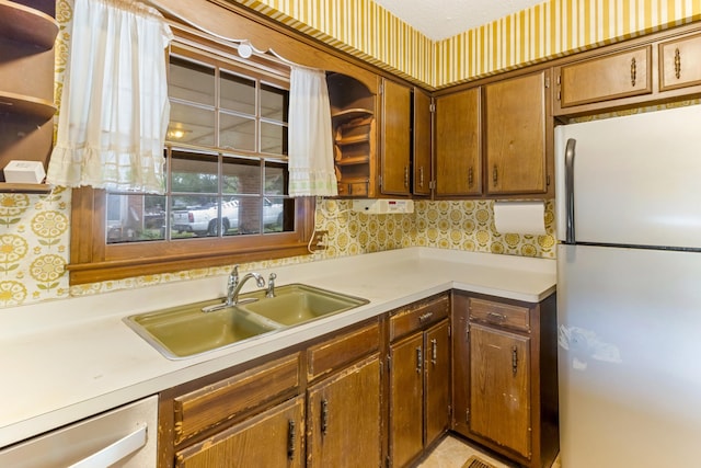 207 Oakmont Dr, Spartanburg, SC 29316 - kitchen with freestanding refrigerator, dishwasher, light countertops, and brown cabinetry