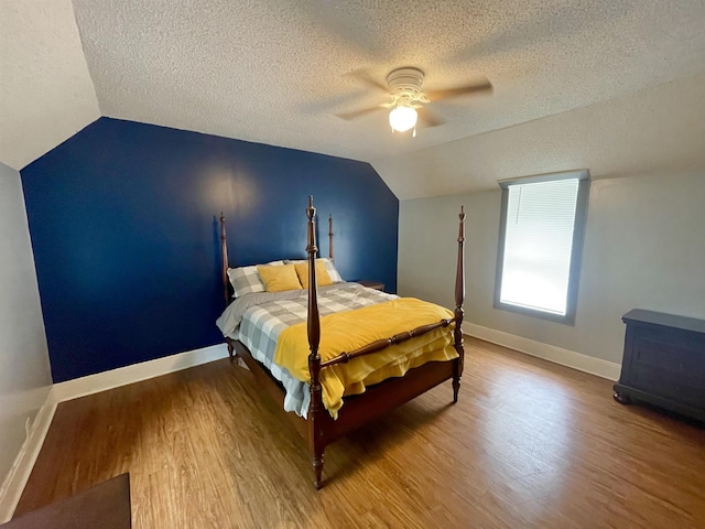 511 El Bethel Rd, Gaffney, SC 29340 - bedroom with lofted ceiling, a textured ceiling, wood finished floors, a ceiling fan, and a wood stove