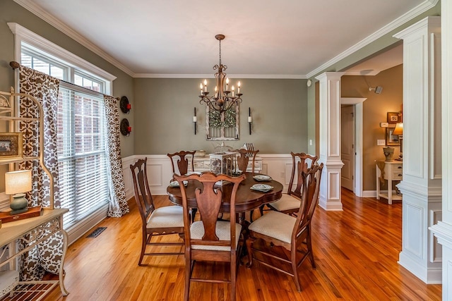 228 Antrim, Moore, SC 29369 - dining room with decorative columns, light wood-style flooring, ornamental molding, wainscoting, and a chandelier