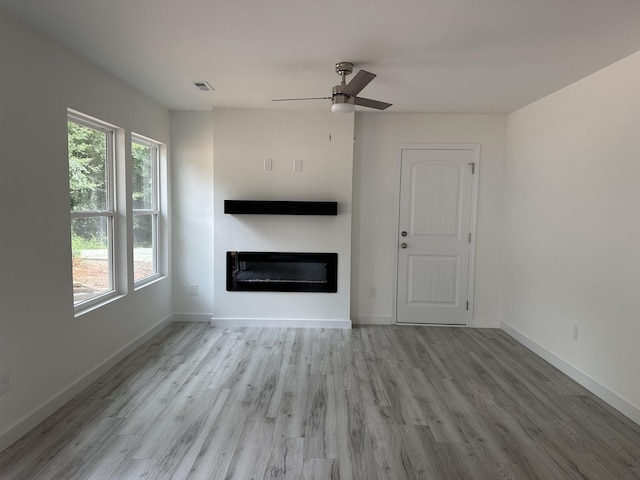 189 Ohio, Chesnee, SC 29323 - unfurnished living room featuring a glass covered fireplace, wood finished floors, and a ceiling fan