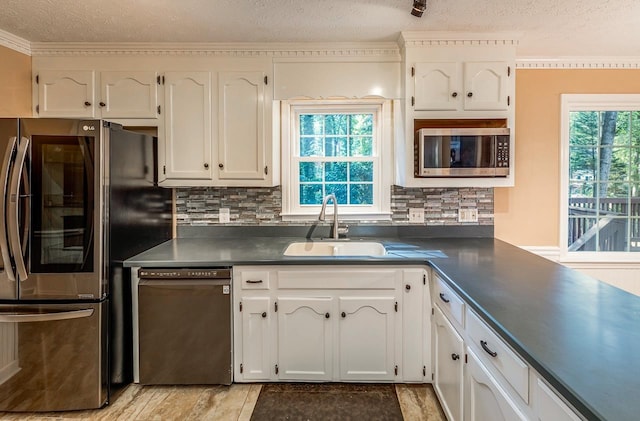 215 E Shefford, Greer, SC 29650 - kitchen with appliances with stainless steel finishes, dark countertops, a textured ceiling, white cabinets, and tasteful backsplash
