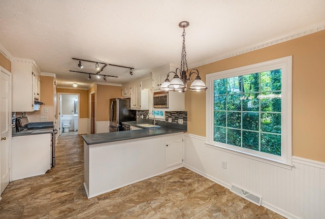 215 E Shefford, Greer, SC 29650 - kitchen with freestanding refrigerator, stove, wainscoting, stainless steel microwave, and a chandelier