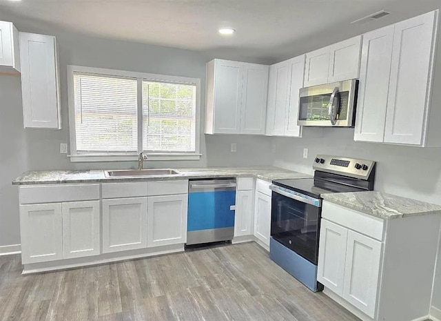 1547 Farley Ave, Spartanburg, SC 29306 - kitchen featuring stainless steel appliances, light wood-style floors, white cabinets, light stone counters, and recessed lighting