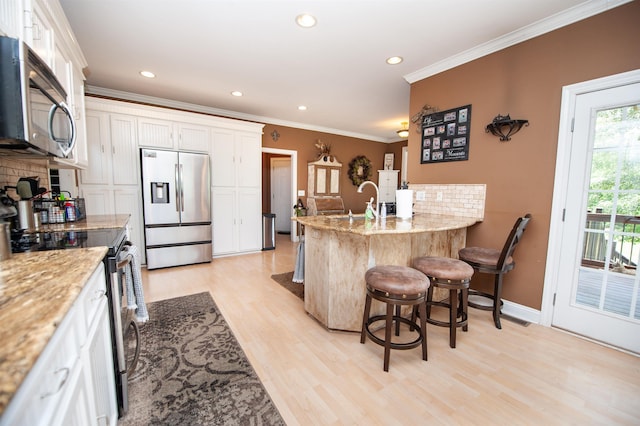 2650 Rainbow Lake Rd, Inman, SC 29349 - kitchen with appliances with stainless steel finishes, a kitchen breakfast bar, light wood-style floors, crown molding, and a peninsula