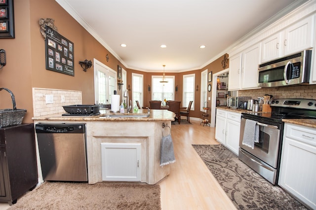 2650 Rainbow Lake Rd, Inman, SC 29349 - kitchen featuring appliances with stainless steel finishes, ornamental molding, tasteful backsplash, a peninsula, and white cabinets