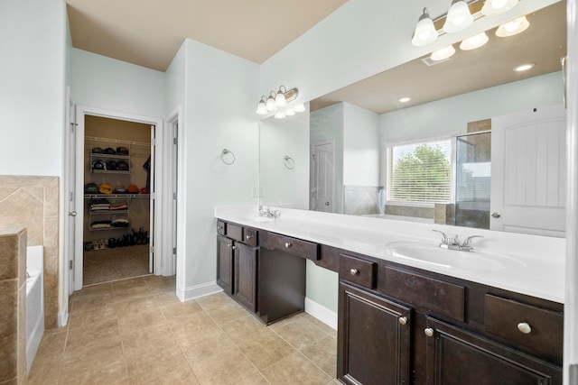 415 Bridge Xing, Simpsonville, SC 29681 - full bathroom with double vanity, a spacious closet, a shower stall, a bath, and tile patterned floors