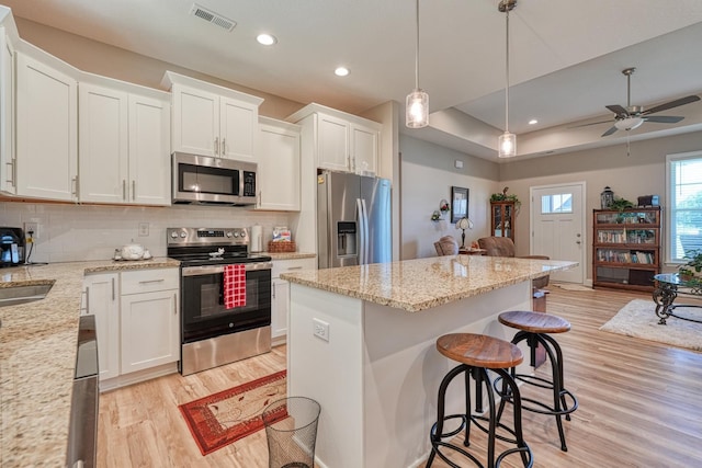 119 W Caylee, Chesnee, SC 29323 - kitchen featuring stainless steel appliances, light wood finished floors, a kitchen breakfast bar, a kitchen island, and white cabinets
