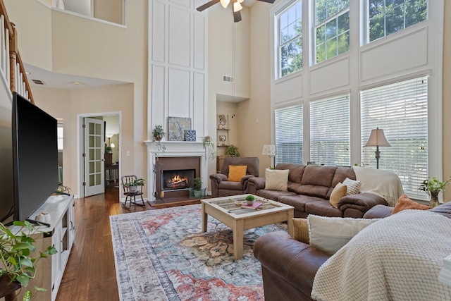 514 Collingsworth, Greenville, SC 29615 - living room featuring a towering ceiling, ceiling fan, a warm lit fireplace, and dark wood finished floors
