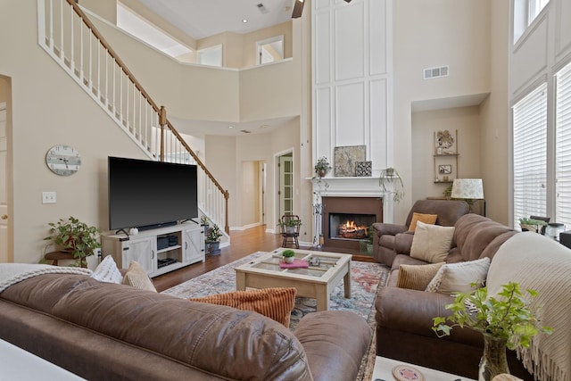 514 Collingsworth, Greenville, SC 29615 - living area featuring stairway, a high ceiling, wood finished floors, and a warm lit fireplace