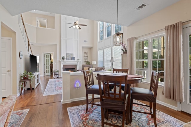 514 Collingsworth, Greenville, SC 29615 - dining room with dark wood-type flooring, a fireplace, a ceiling fan, and a towering ceiling