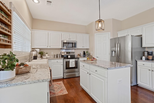 514 Collingsworth, Greenville, SC 29615 - kitchen featuring appliances with stainless steel finishes, white cabinetry, dark wood-style flooring, and a kitchen island
