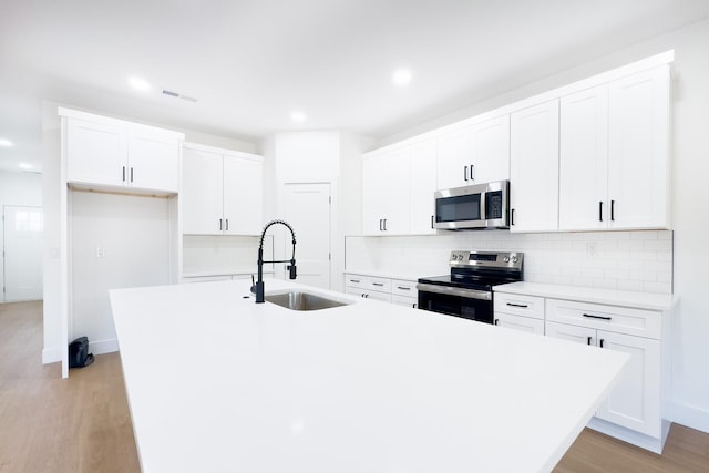 634 N Green Riv, Gaffney, SC 29341 - kitchen with stainless steel appliances, an island with sink, tasteful backsplash, light wood-style flooring, and recessed lighting