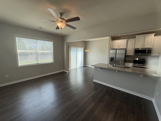 158 Clingstone, Duncan, SC 29334 - kitchen with appliances with stainless steel finishes, ceiling fan, dark wood-style floors, stone countertops, and a kitchen bar
