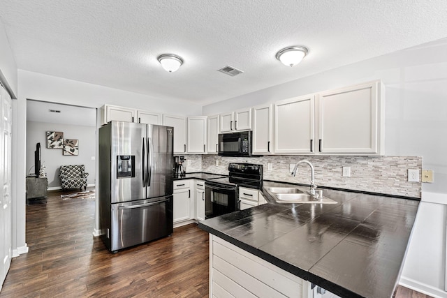 308 Juniper Leaf, Greer, SC 29651 - kitchen with black appliances, dark countertops, a peninsula, decorative backsplash, and dark wood-style flooring