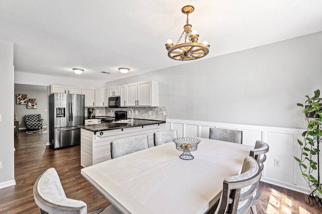 308 Juniper Leaf, Greer, SC 29651 - dining area featuring a chandelier, dark wood-type flooring, wainscoting, and a decorative wall