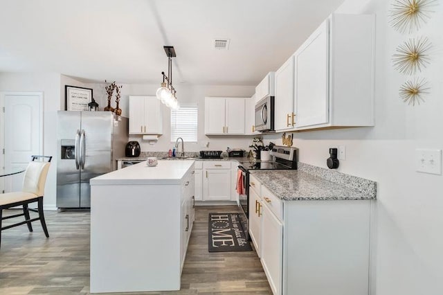 226 Christopher St, Duncan, SC 29334 - kitchen featuring stainless steel appliances, wood finished floors, a center island, and white cabinets