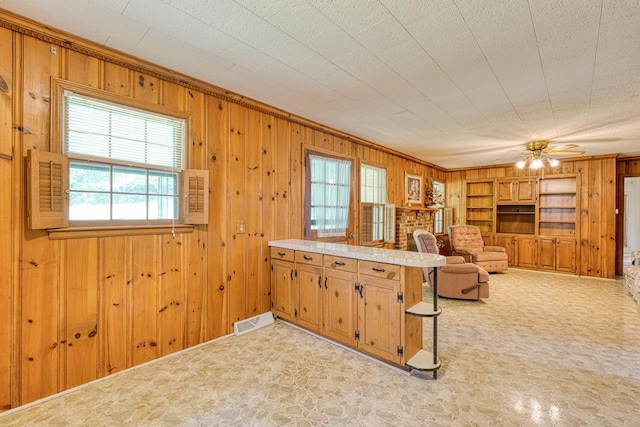 104 Pine, Laurens, SC 29360 - kitchen featuring wood walls, light flooring, ceiling fan, a peninsula, and light countertops