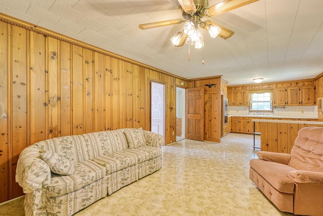 104 Pine, Laurens, SC 29360 - living area with wooden walls, ceiling fan, crown molding, and light flooring