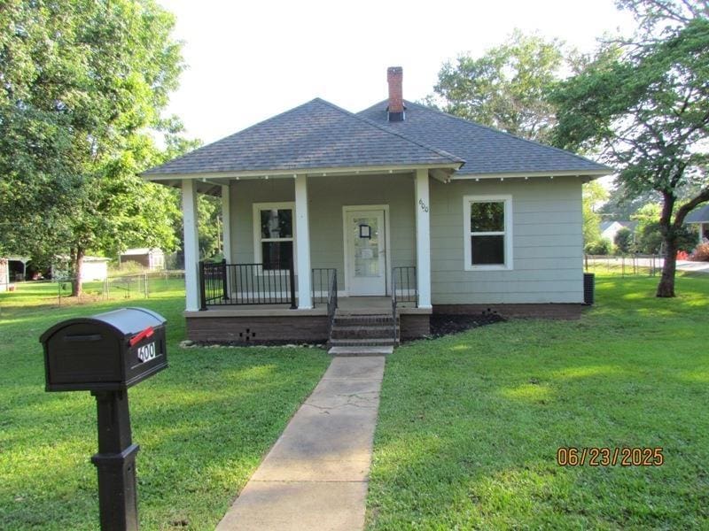 600 Swygert, Laurens, SC 29360 - bungalow with a shingled roof, covered porch, a front yard, and a chimney