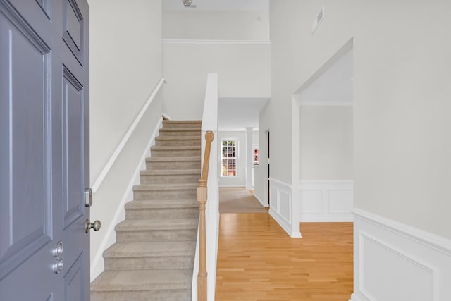 8 Glenbow, Simpsonville, SC 29680 - foyer featuring stairway, light wood-style floors, a decorative wall, and wainscoting