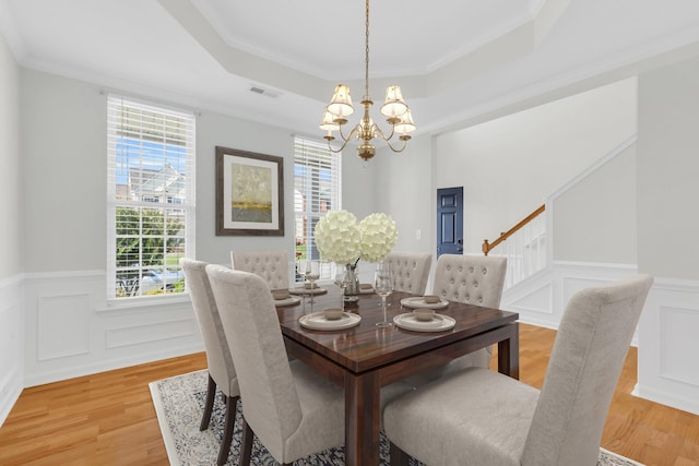 8 Glenbow, Simpsonville, SC 29680 - dining area featuring a raised ceiling, a chandelier, plenty of natural light, a wainscoted wall, and light wood-style floors