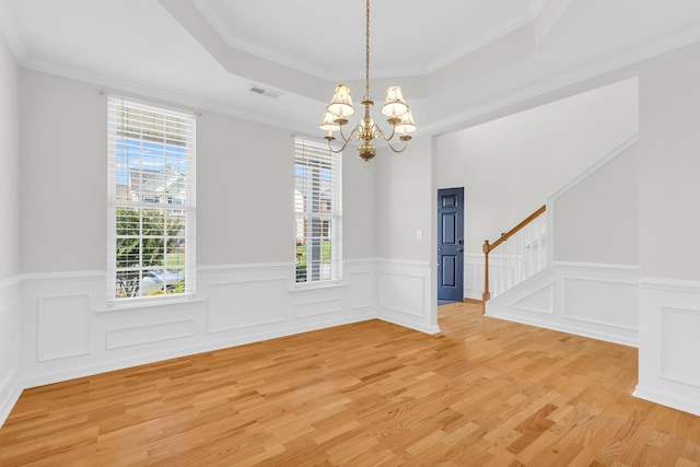 8 Glenbow, Simpsonville, SC 29680 - empty room featuring a chandelier, a raised ceiling, stairs, light wood-type flooring, and wainscoting